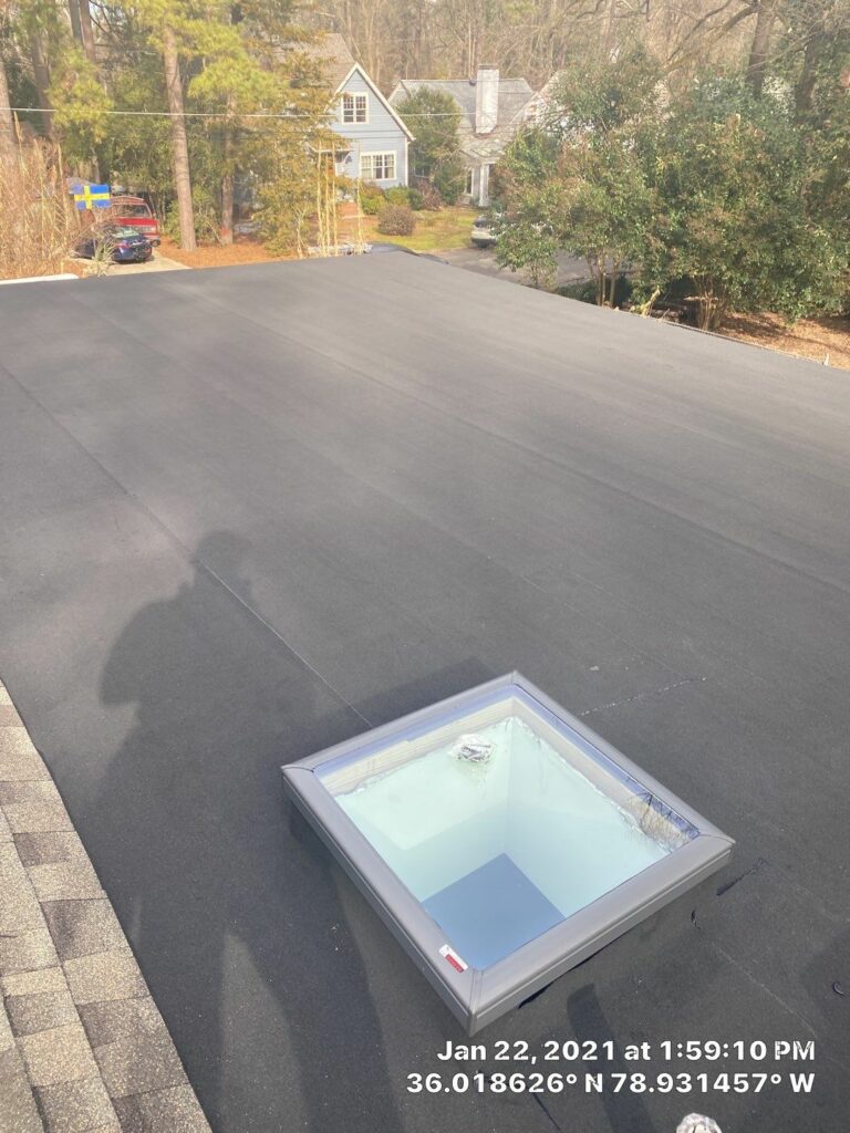 Acrylic bubbled skylight replaced with VELUX fixed curb mounted unit on a flat roof